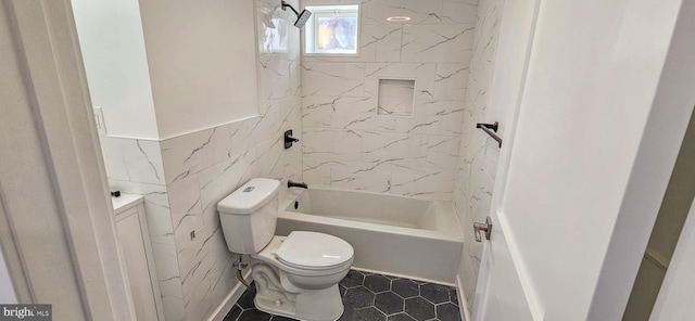 bathroom featuring tile patterned floors, toilet, tile walls, washtub / shower combination, and vanity