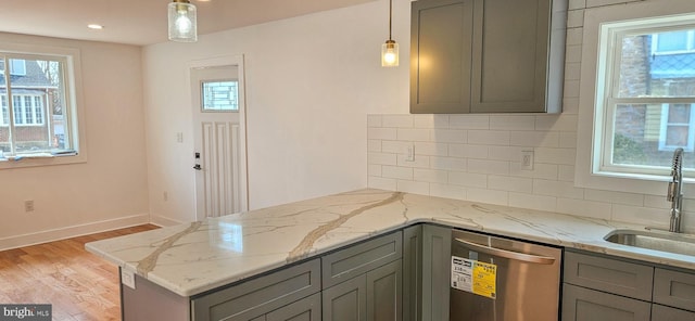 kitchen with a sink, gray cabinetry, light wood-type flooring, and stainless steel dishwasher