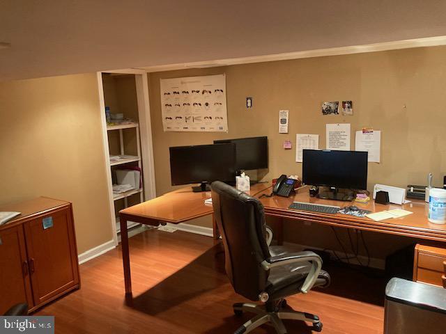 office with baseboards, wood finished floors, and crown molding