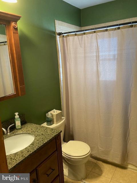 full bath with tile patterned floors, toilet, vanity, and a shower with curtain