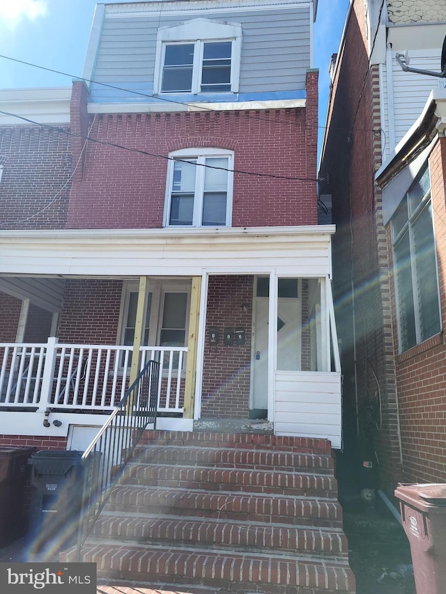 view of front of property with brick siding and a porch