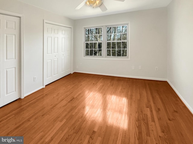 unfurnished bedroom featuring hardwood / wood-style floors, a ceiling fan, and baseboards