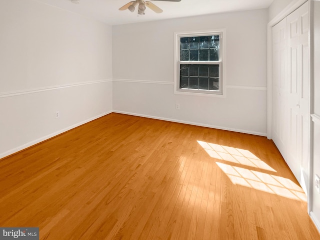 unfurnished bedroom featuring a closet, a ceiling fan, light wood-type flooring, and baseboards