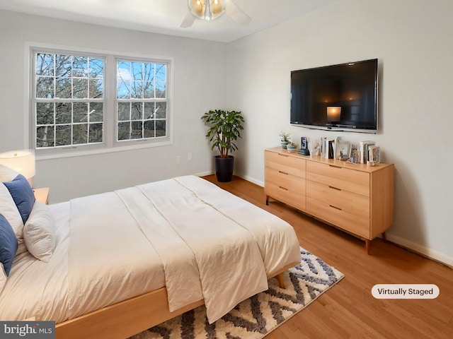 bedroom with baseboards and wood finished floors