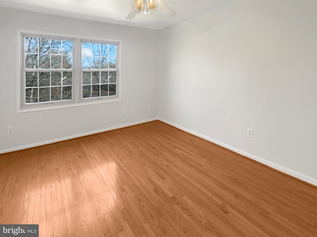 empty room with baseboards, ceiling fan, and hardwood / wood-style flooring