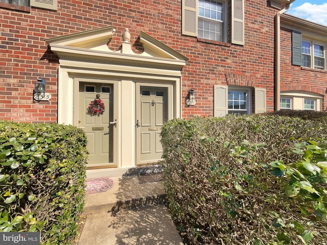 view of exterior entry with brick siding