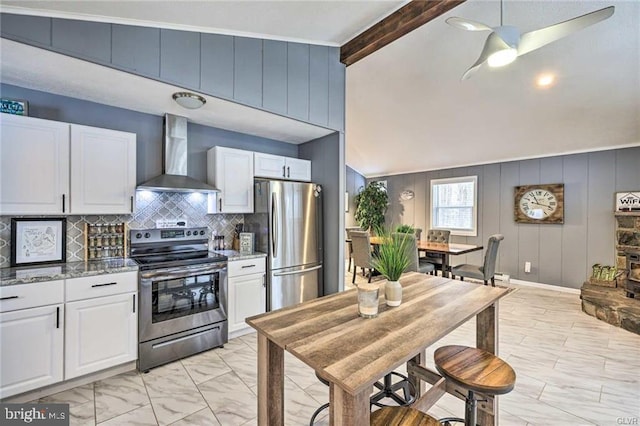 kitchen featuring stainless steel appliances, marble finish floor, wall chimney exhaust hood, and white cabinetry