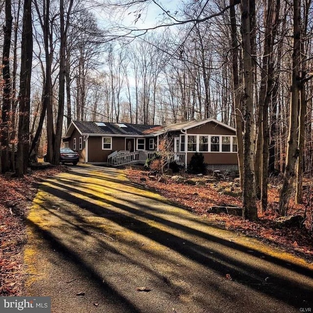 view of front of home featuring a sunroom and driveway