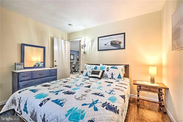 bedroom featuring baseboards and wood finished floors