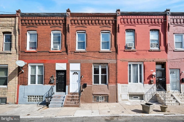 view of property with cooling unit, brick siding, and entry steps