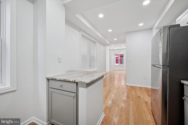 kitchen with light wood-type flooring, gray cabinetry, freestanding refrigerator, recessed lighting, and baseboards