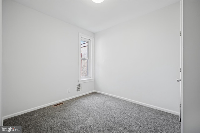 spare room featuring carpet flooring, visible vents, and baseboards