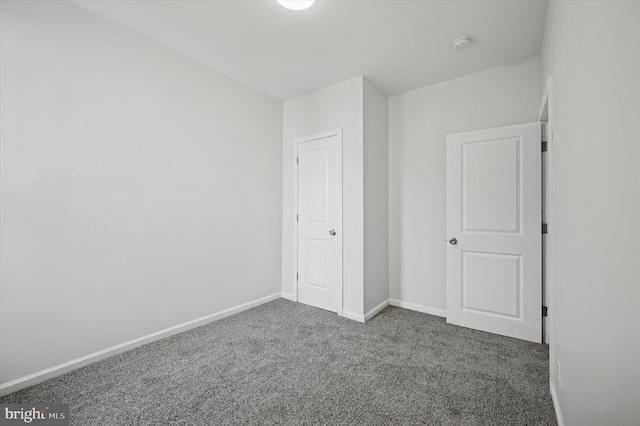 unfurnished bedroom with baseboards and carpet