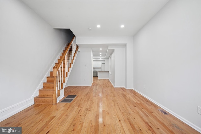 interior space with visible vents, baseboards, stairs, and light wood-style floors