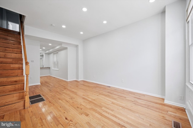 unfurnished living room with stairs, recessed lighting, light wood-style floors, and visible vents