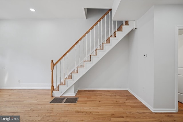 staircase featuring recessed lighting, baseboards, and wood finished floors