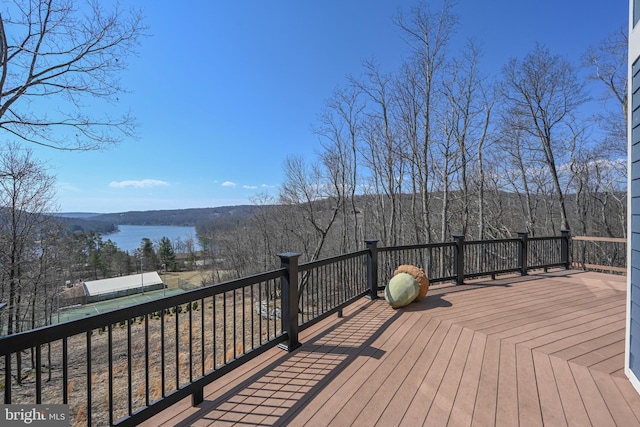 wooden terrace with a view of trees and a water view