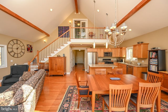 dining room featuring stairway, high vaulted ceiling, an inviting chandelier, light wood-style flooring, and beamed ceiling