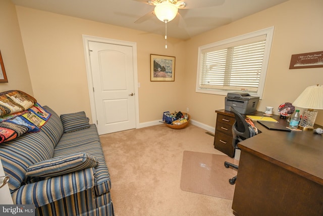 carpeted office with a ceiling fan and baseboards