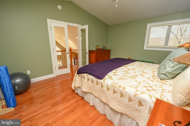 bedroom featuring baseboards, lofted ceiling, and wood finished floors