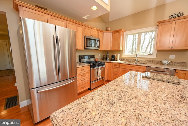 kitchen featuring light brown cabinets, visible vents, appliances with stainless steel finishes, and a sink