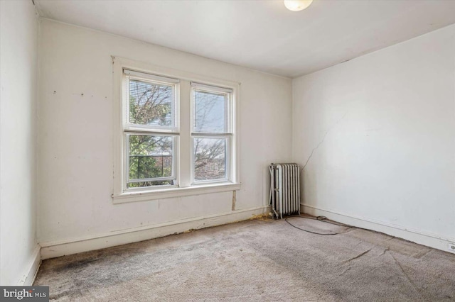 carpeted spare room featuring radiator