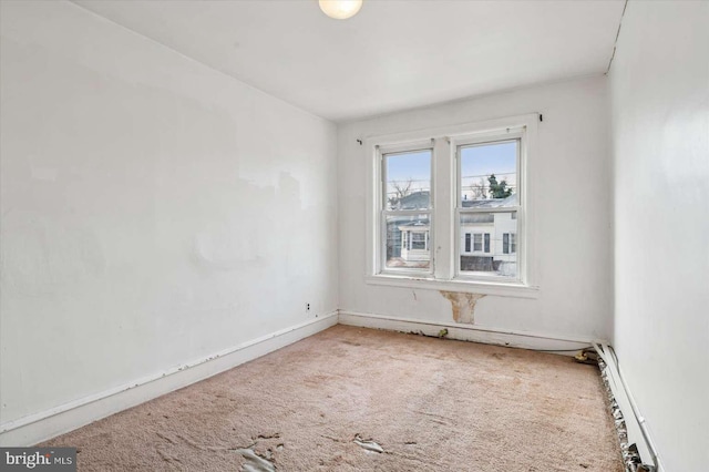 carpeted spare room featuring baseboard heating