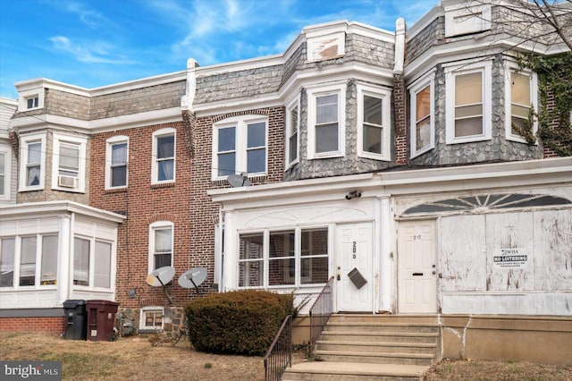 view of front of property with brick siding and mansard roof