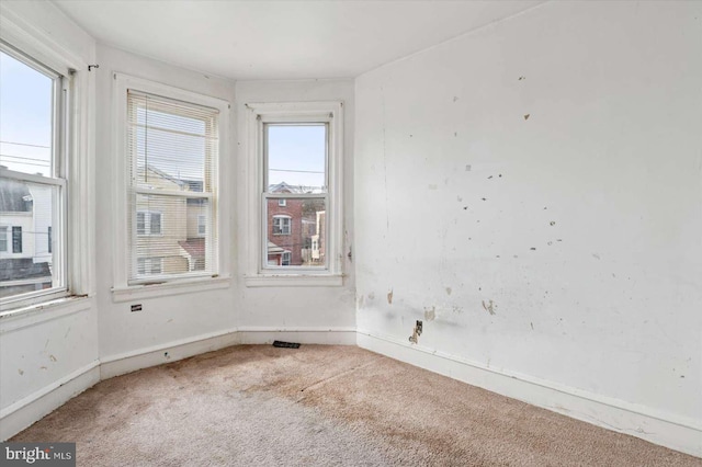 carpeted empty room with baseboards