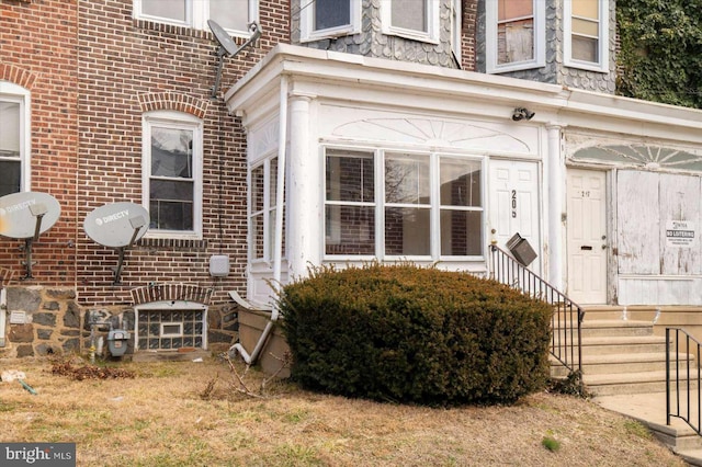 doorway to property featuring brick siding