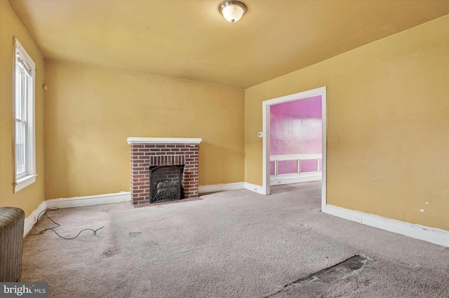 unfurnished living room with carpet flooring, radiator heating unit, baseboards, and a wealth of natural light