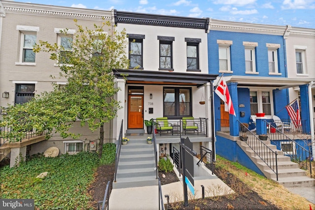 townhome / multi-family property featuring brick siding and a porch