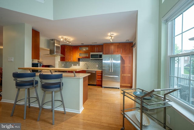 215 Valley Frg, Lookout Place, Wayne, PA 19087 - kitchen with stainless steel appliances, extractor fan, a peninsula, brown cabinetry, and track lighting