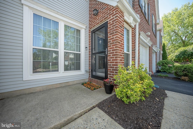215 Valley Frg, Lookout Place, Wayne, PA 19087 - view of exterior entry featuring brick siding and a garage
