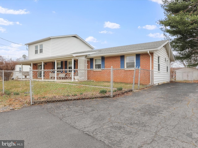 view of front facade featuring a fenced front yard, driveway, and a porch