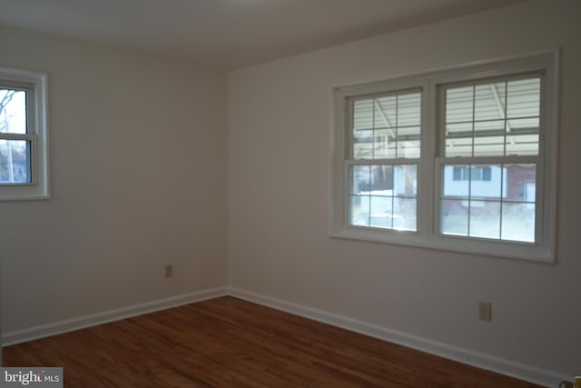 spare room featuring wood finished floors and baseboards