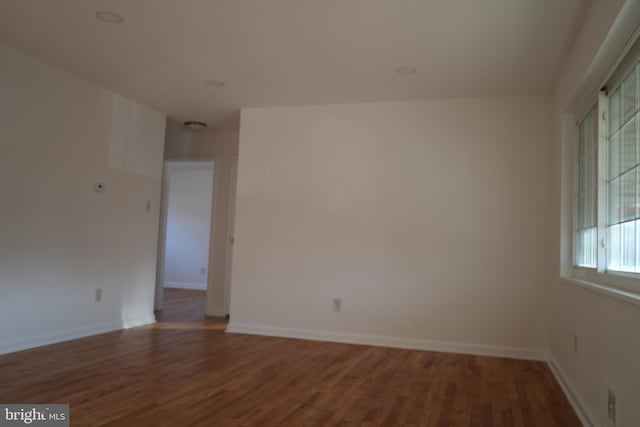 empty room with wood finished floors and baseboards