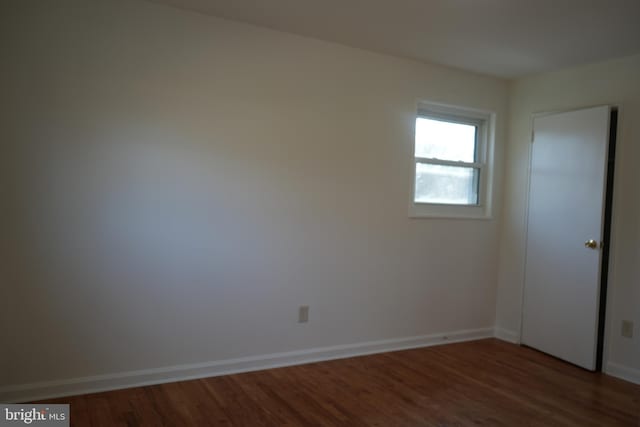 empty room with wood finished floors and baseboards