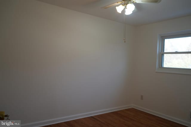 spare room with visible vents, baseboards, a ceiling fan, and dark wood-style flooring