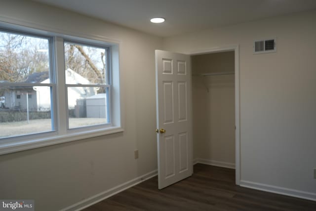 unfurnished bedroom with baseboards, visible vents, recessed lighting, dark wood-type flooring, and a closet