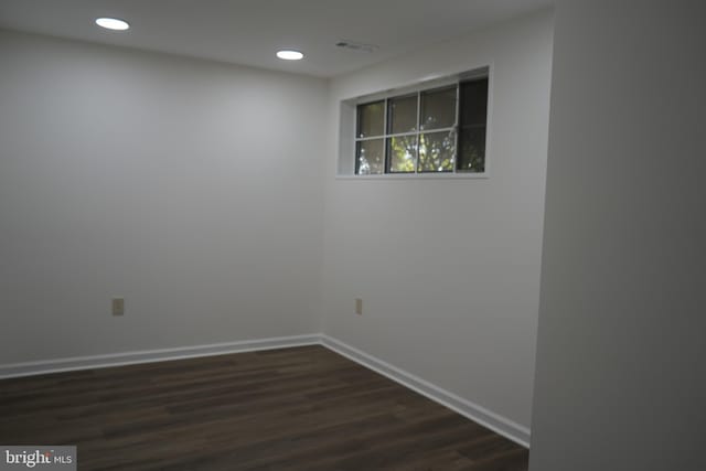 unfurnished room with visible vents, recessed lighting, baseboards, and dark wood-style flooring