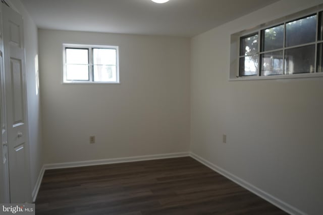 empty room featuring baseboards and dark wood-style flooring