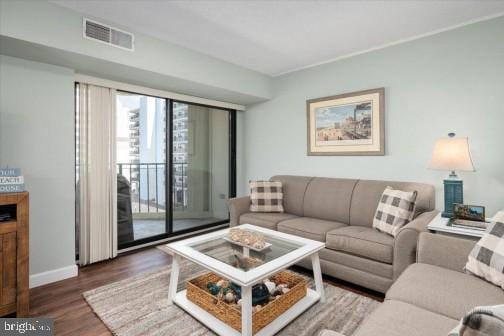 living area with visible vents, baseboards, and wood finished floors