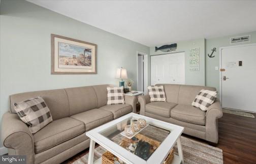 living area featuring visible vents and wood finished floors