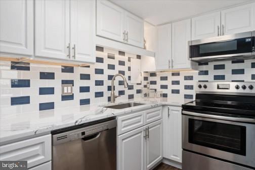 kitchen with white cabinetry, appliances with stainless steel finishes, and a sink