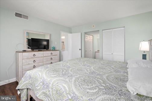 bedroom featuring dark wood-style floors and visible vents