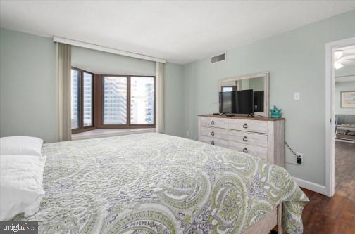 bedroom featuring visible vents, baseboards, and wood finished floors