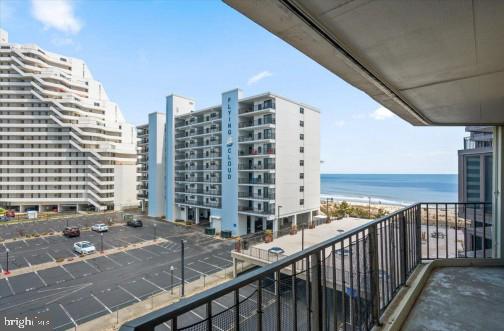 balcony featuring a beach view and a water view