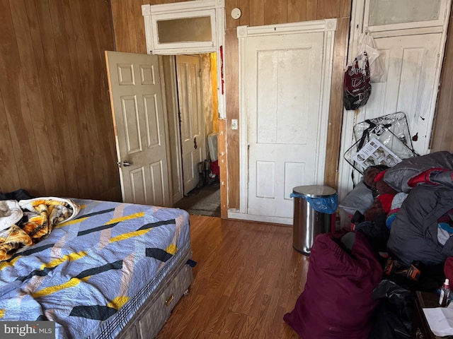 bedroom with wood finished floors and wood walls