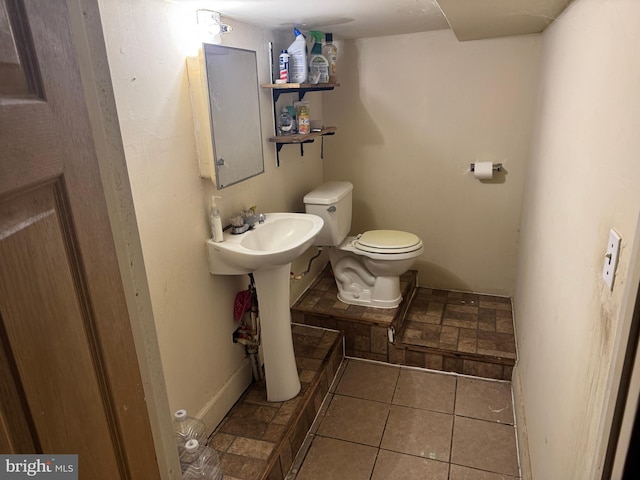 half bath with toilet and tile patterned flooring